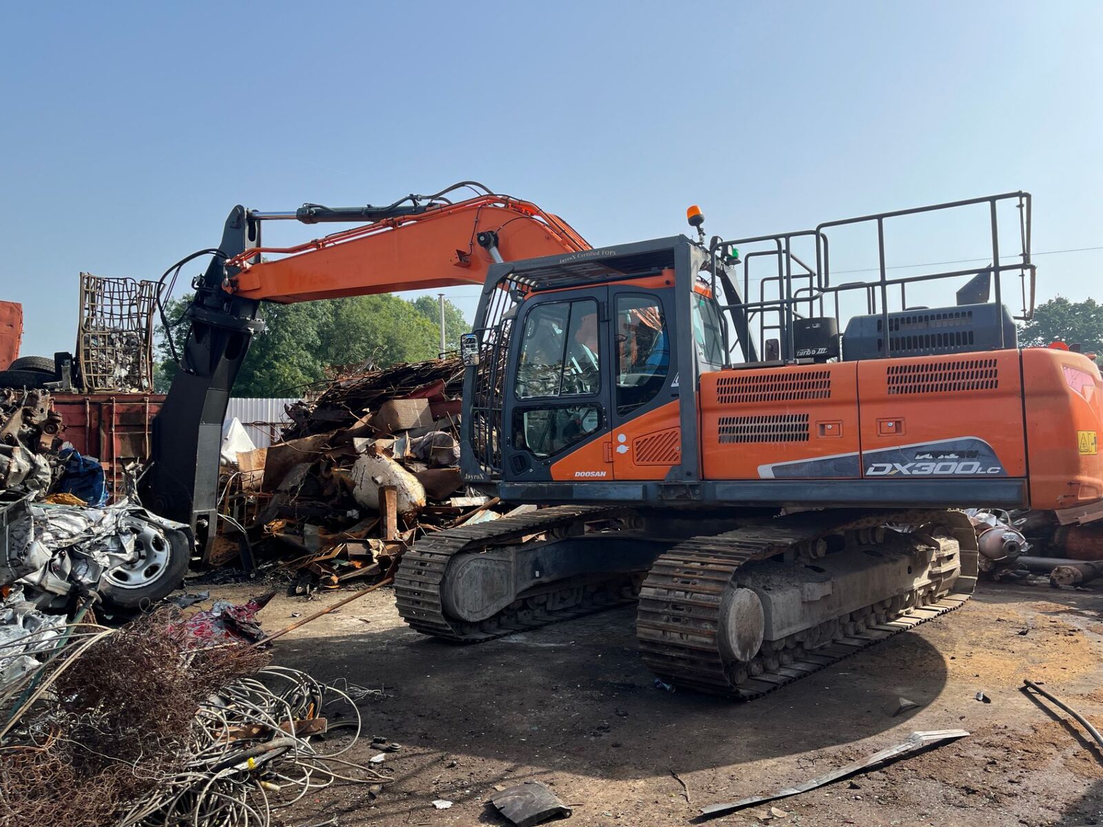 Excavator sorting scrap at the yard