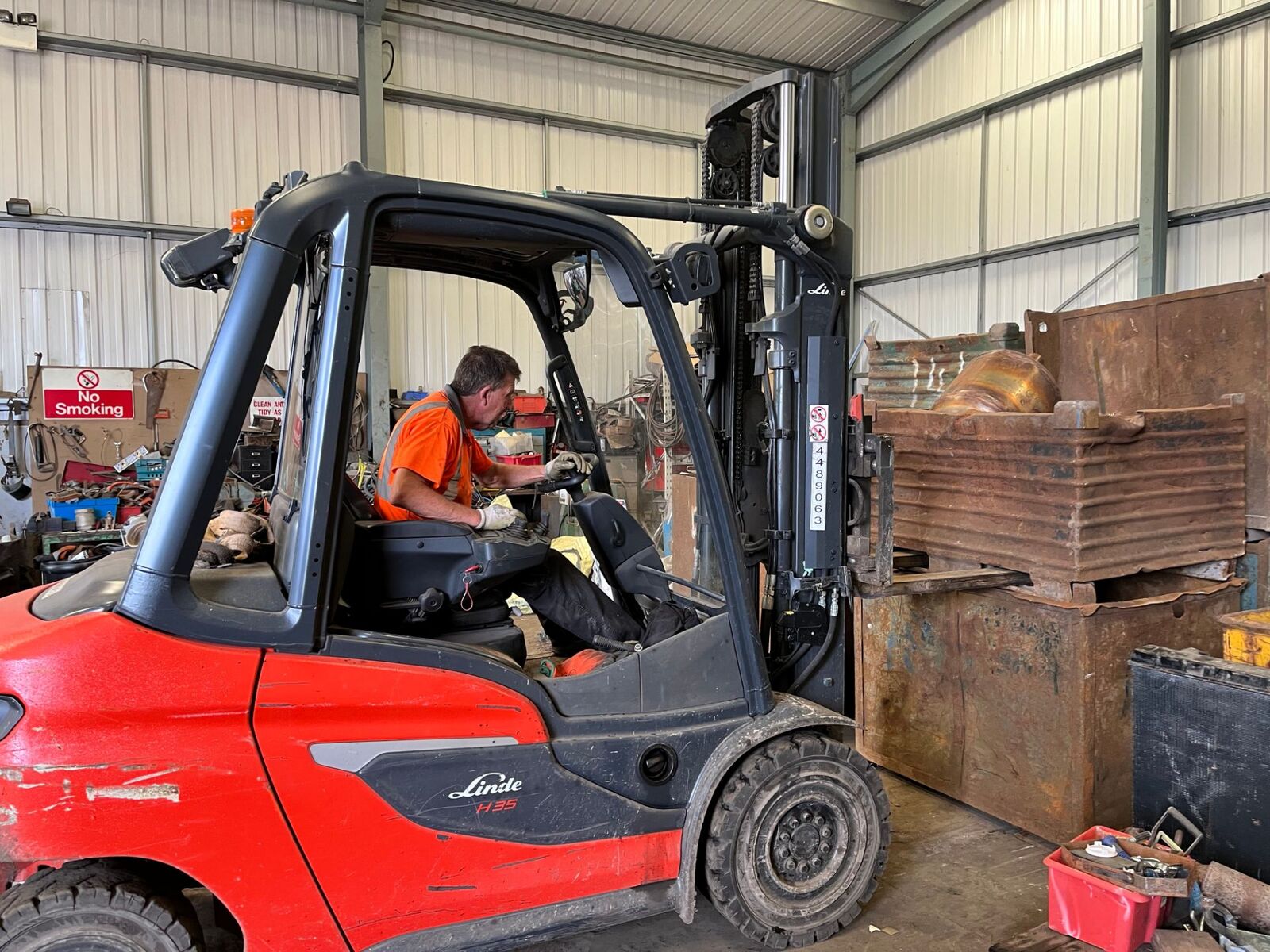 Forklift moving scrap metal inside the processing shed