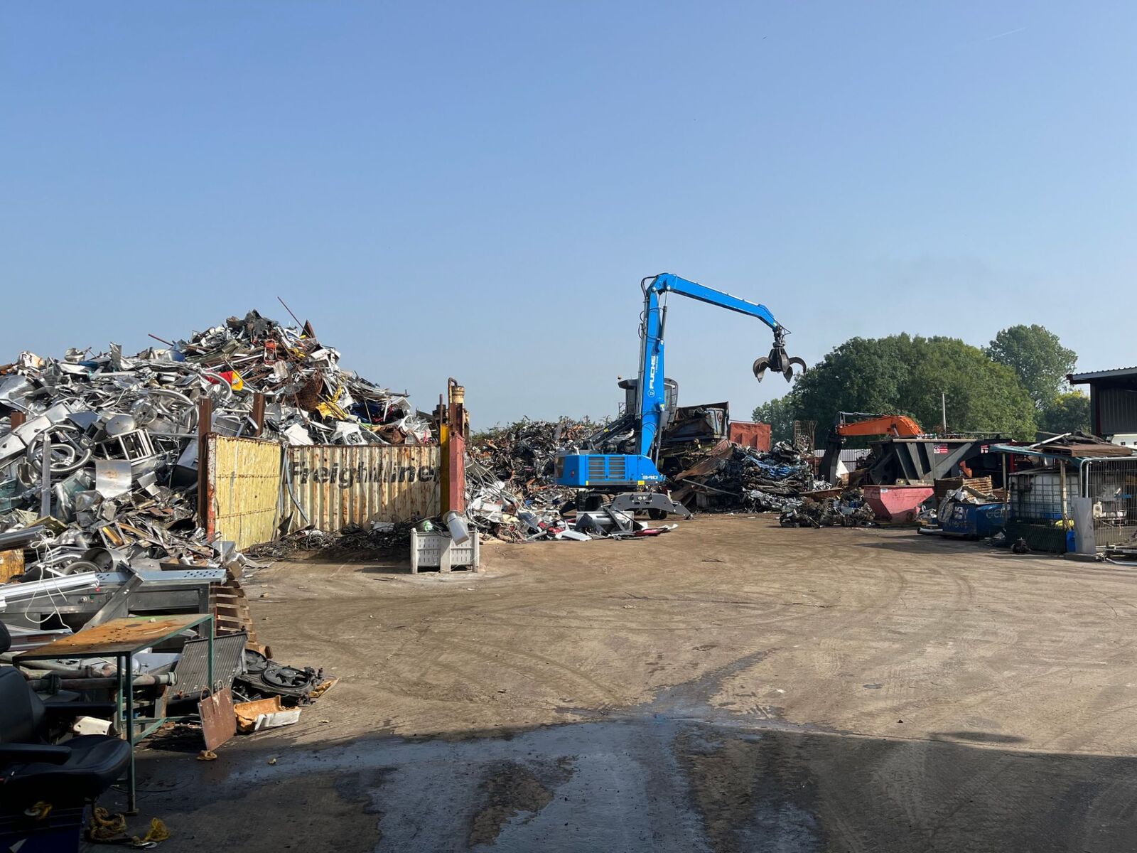 Wide view of the yard with the grab machine loading scrap