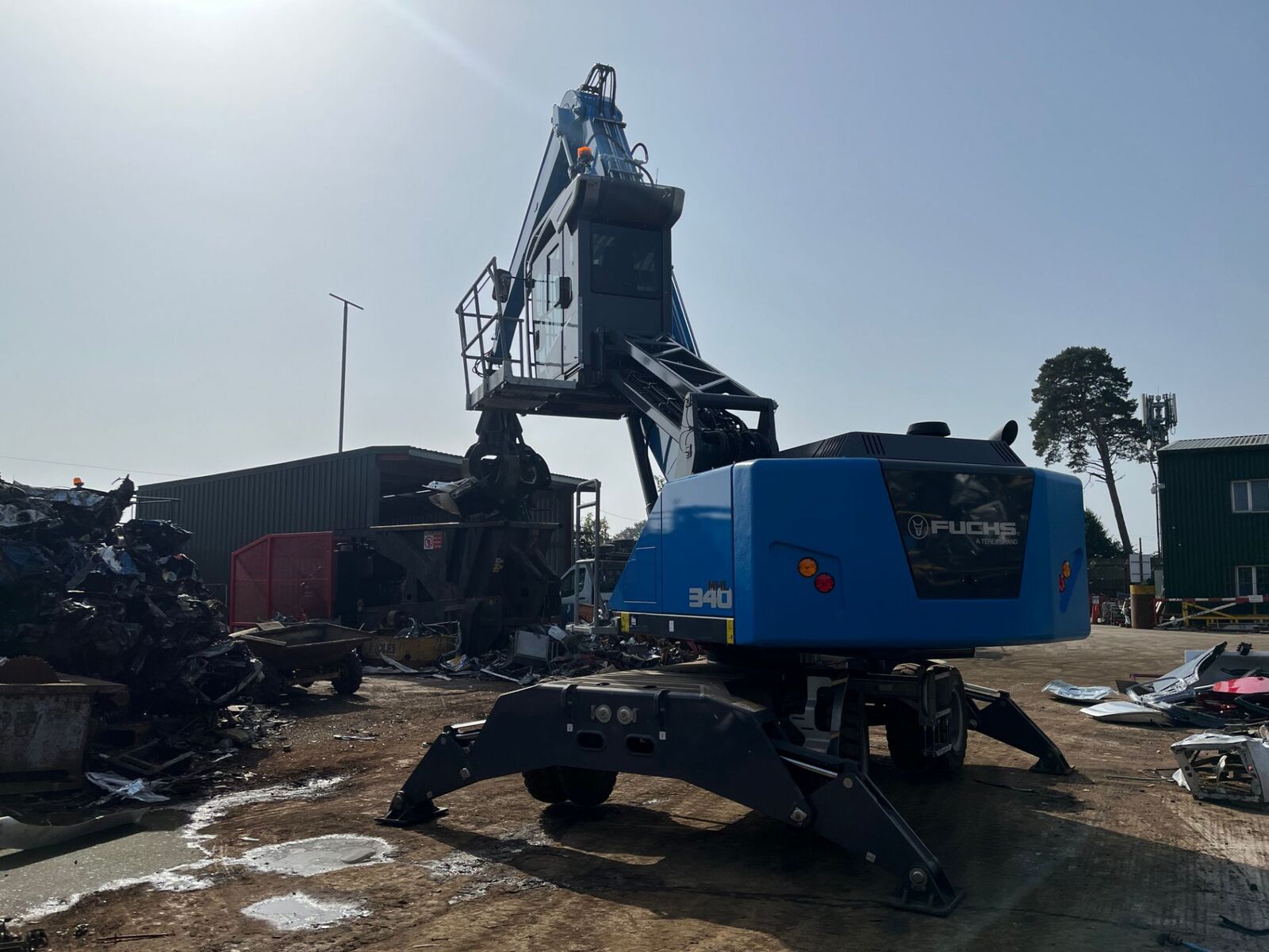 Blue material handler working a pile of scrap metal