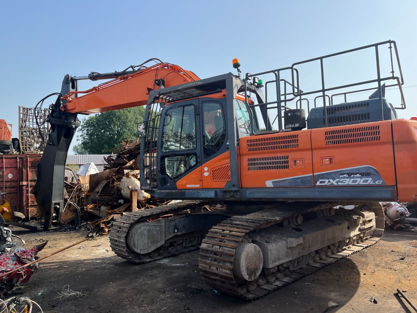 Tracked excavator with a scrap grab attachment