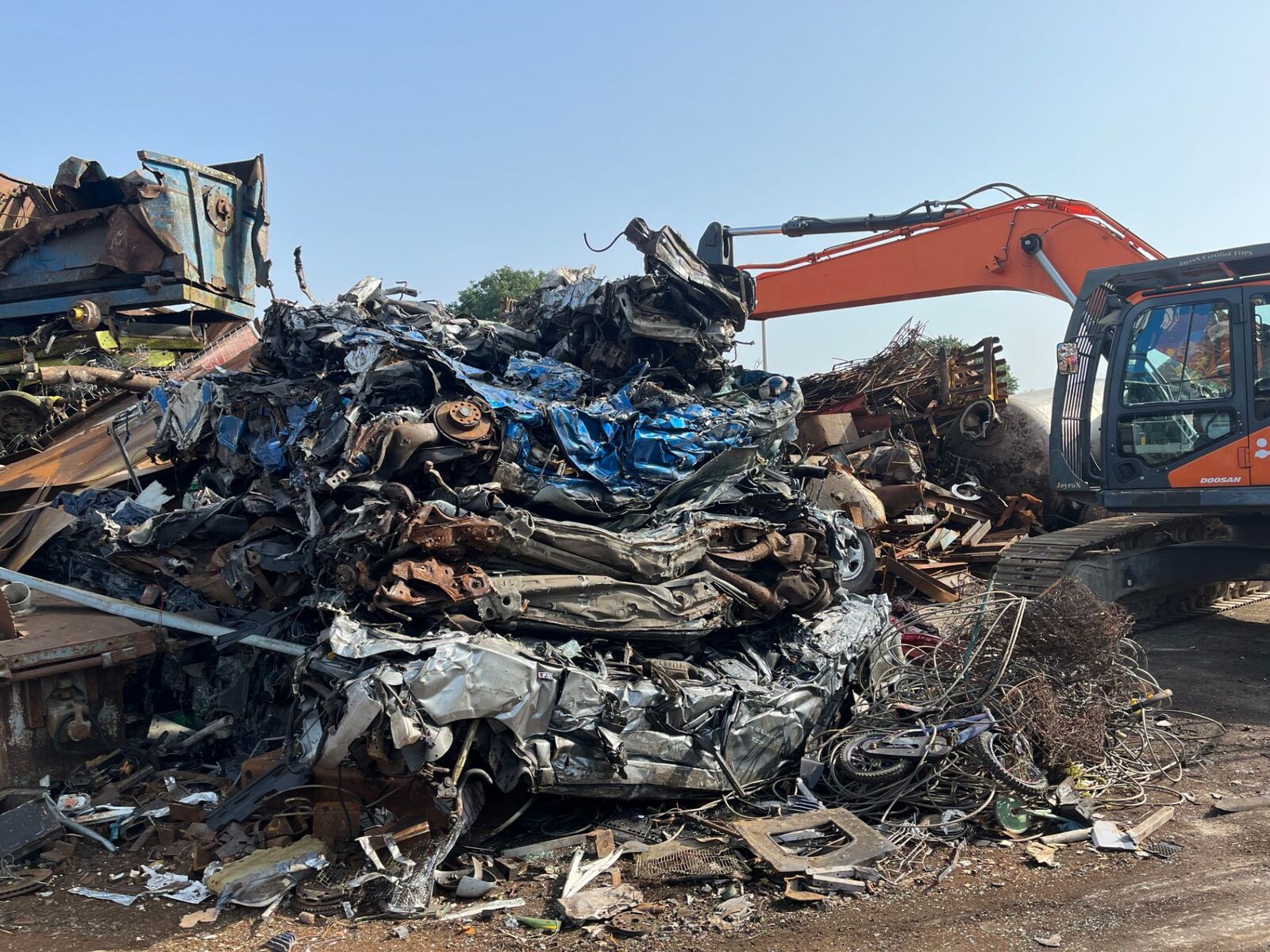 Large pile of mixed scrap being worked by machine